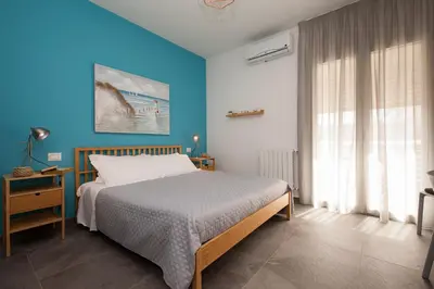 a bedroom with a bed and a blue wall at Nerissa suites&rooms in Terrasini