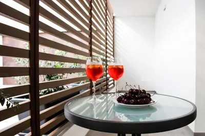 two glasses of wine on a table with a bowl of fruit at Case vacanza Puccini in Alcamo