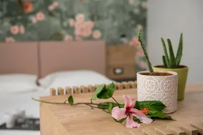 a wooden table with two vases and a flower on it at Case vacanza Puccini in Alcamo