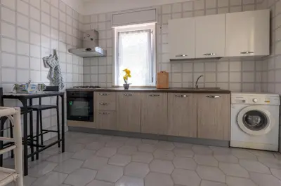 a kitchen with a sink and a washing machine at Butterfly House in Trappeto