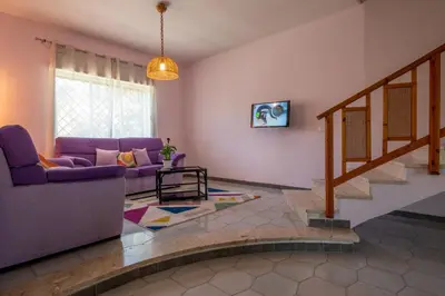 a living room with a purple couch and stairs at Butterfly House in Trappeto