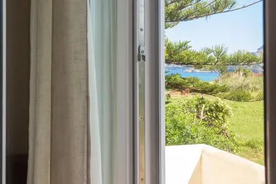 a sliding glass door with a view of the ocean at Butterfly House in Trappeto