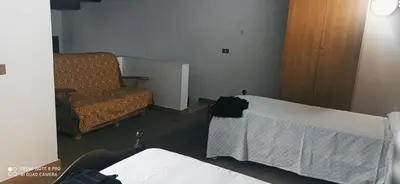 a living room with a bed and a chair at House Italia Holiday in Trabia