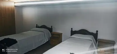 a bedroom with two beds and a wooden dresser at House Italia Holiday in Trabia