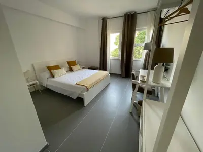 a white bedroom with a bed and a window at Milu's Home in Palermo
