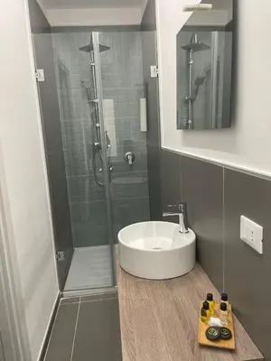 a bathroom with a white sink and a shower at Milu's Home in Palermo