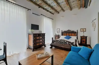 a bedroom with a bed and a couch and a table at iFlat Palazzo Ragusi in Palermo