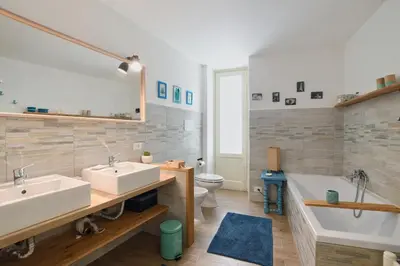 a bathroom with two sinks and a tub and a toilet at iFlat Palazzo Ragusi in Palermo