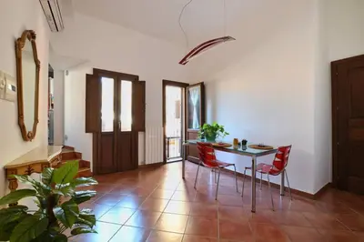 a living room with a table and red chairs at iFlat Casa Tesò con terrazza sui tetti in Palermo