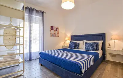 a bedroom with a blue bed and a window at 2 Bedroom Amazing Apartment In Trappeto in Trappeto
