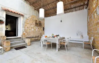 a dining room with a white table and chairs at 2 Bedroom Amazing Apartment In Trappeto in Trappeto