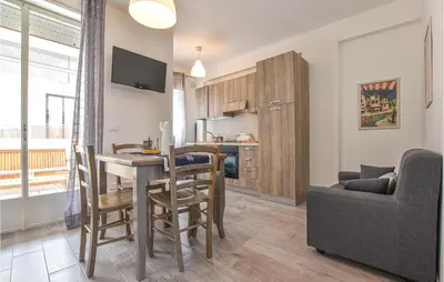 a kitchen and living room with a table and a couch at 2 Bedroom Amazing Apartment In Trappeto in Trappeto