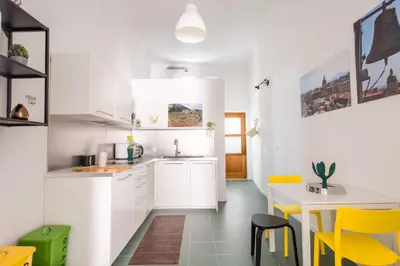 a living room with a white table and yellow chairs at Vucciria Apartments by Wonderful Italy in Palermo