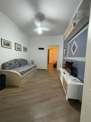 a bedroom with a bed and a desk and a television at Luna Blu Apartment in Palermo