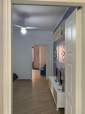 a hallway with a living room with a tv and a ceiling at Luna Blu Apartment in Palermo