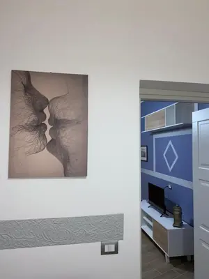 a painting of a couple kissing in a bedroom at Luna Blu Apartment in Palermo