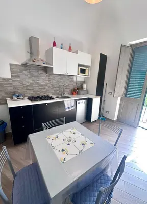 a kitchen with a table and chairs in a room at Luna Blu Apartment in Palermo
