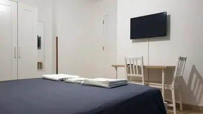 a bedroom with a bed and a table and a television at Sweet Home in Palermo