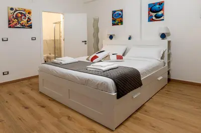 a large bed in a bedroom with white walls at Sweet Home in Palermo