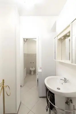 a white bathroom with a sink and a toilet at Monolocale Sant'Andrea in Palermo