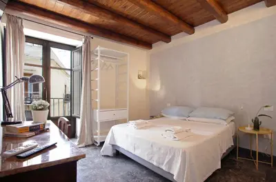 a bedroom with a bed and a desk and a window at Casa Miqvà - Rooms in shared apartment in Palermo