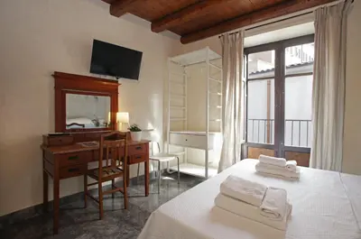 a bedroom with a desk and a bed and a mirror at Casa Miqvà - Rooms in shared apartment in Palermo