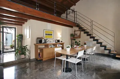 a dining room with a table and a staircase at Casa Miqvà - Rooms in shared apartment in Palermo