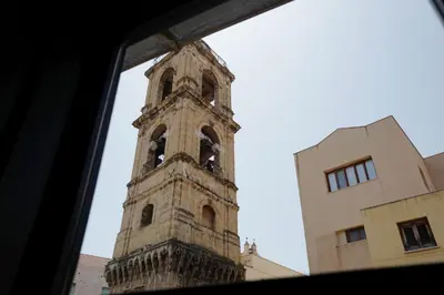 a tall clock tower in front of a building at Casa Miqvà - Rooms in shared apartment in Palermo