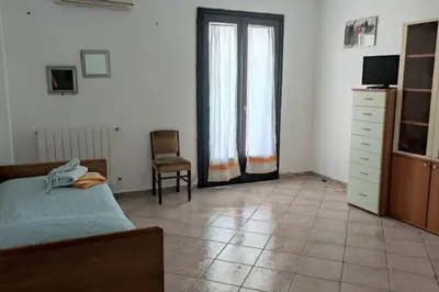 a bedroom with a bed and a chair in it at Casa del Grecale in Isola delle Femmine