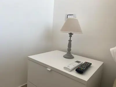 a table with a lamp and a remote control on it at Villa Serendipity Terrasini in Terrasini
