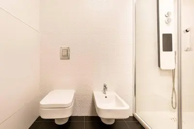 a white bathroom with a toilet and a sink at Palermo old style - Boutique apartment with terrace in center city in Palermo