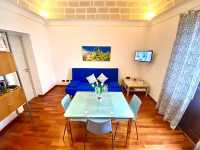 a dining room with a blue couch and a table at Casa Mare in San Vito lo Capo
