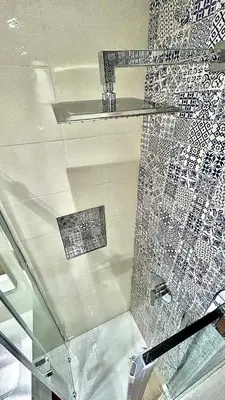 a bathroom with a mosaic wall and a shelf at Casa Mare in San Vito lo Capo
