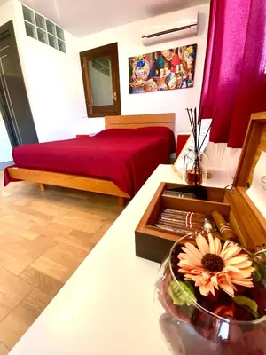 a room with a bed and a bowl of flowers on a table at Casa Sole in San Vito lo Capo