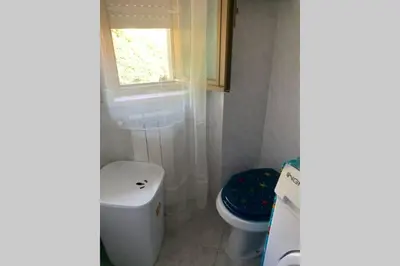 a bathroom with a toilet and a window at Casa vacanza - I Mulini con parcheggio gratuito incluso. in Monreale