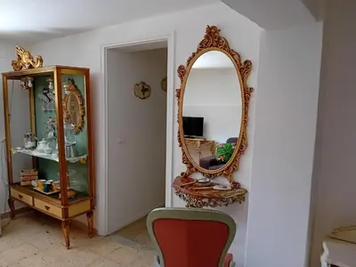 a room with a mirror and a chair and a cabinet at Relais dei Mori Home Palermo in Casteldaccia