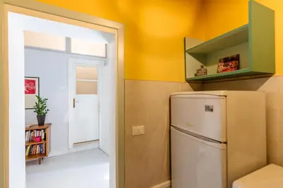 a kitchen with a white refrigerator and a window at Casa Dante with Balcony by Wonderful Italy in Palermo