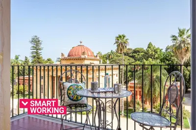 a balcony with a table and chairs on a fence at Un balcone sull'Orto Botanico by Wonderful Italy in Palermo