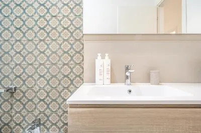 a bathroom with a white sink and a tile wall at Un balcone sull'Orto Botanico by Wonderful Italy in Palermo