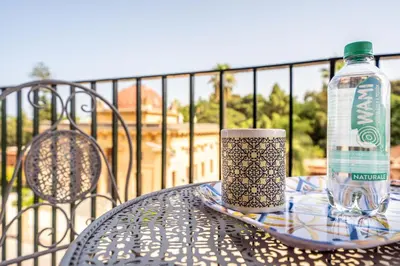 a bottle of water and a cup on a table at Un balcone sull'Orto Botanico by Wonderful Italy in Palermo