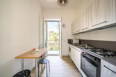 a kitchen with a table and a stove top oven at Un balcone sull'Orto Botanico by Wonderful Italy in Palermo