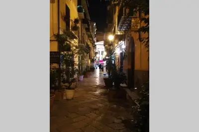 an alley at night with a person walking down the street at Fra la città storica e quella ottocentesca in Palermo