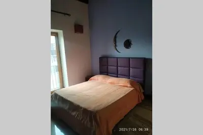 a bedroom with a bed with a purple head board at Fra la città storica e quella ottocentesca in Palermo