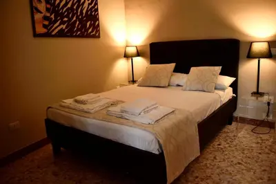 a bedroom with a large bed with towels on it at Due Cani in Palermo