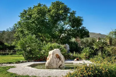 a small pond with a rock in a garden at Villa Giuliana in Castellammare del Golfo