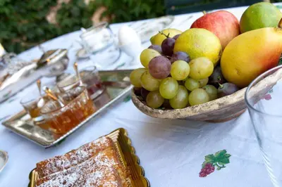 a bowl of fruit on a table with a plate of food at Il Glicine sul Golfo in Mondello