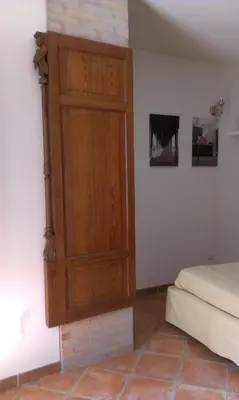 a bedroom with a wooden door on the wall at Home Resuttano in Palermo