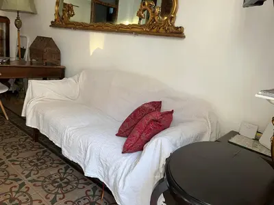 a white couch with two red pillows in a room at FraLePorte Vintage Apartment in Palermo