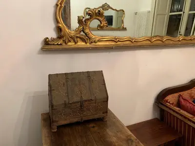 a mirror and a wooden box sitting on a floor at FraLePorte Vintage Apartment in Palermo