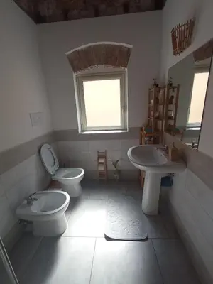 a bathroom with two toilets and a sink and a window at ZyZ Apartments La Kalsa in Palermo